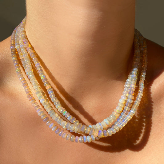Shimmering beaded necklace made of faceted opals in shades of clear and light lilac on a gold linking ovals clasp. 
