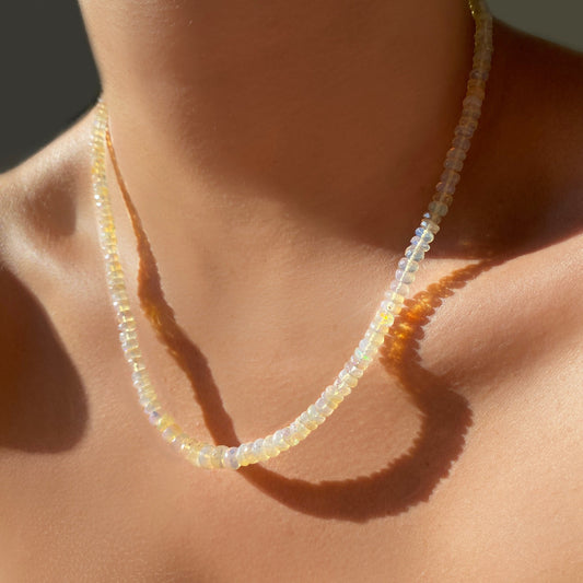 Shimmering beaded necklace made of faceted opals in shades of clear and nude opals on a gold linking ovals clasp. 