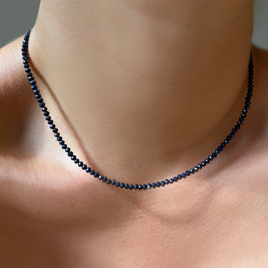 Shimmering beaded necklace made of 2.5mm faceted opals in shades of black on a gold linking lobster clasp. 