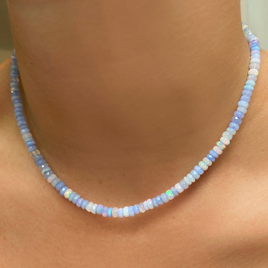 Shimmering beaded necklace made of faceted opals in shades of light pastel blue and white on a gold linking ovals clasp. 
