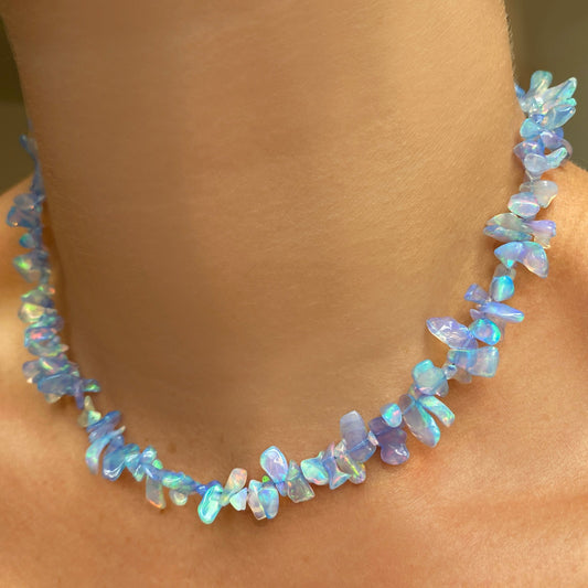 Shimmering beaded necklace made of rough opals in shades of pastel blue on a gold linking ovals clasp.