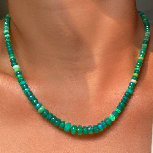 Shimmering beaded necklace made of faceted opals in shades of green on a gold linking ovals clasp. 