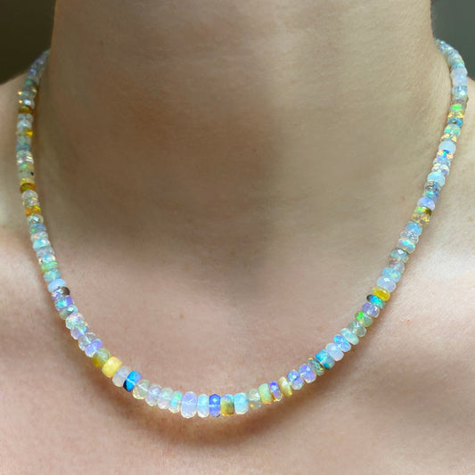 Shimmering beaded necklace made of faceted opals in shades of white, clear, and yellow on a gold linking ovals clasp. 