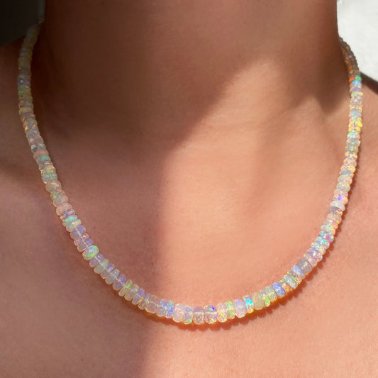 Shimmering beaded necklace made of faceted opals in shades of clear opals on a gold linking ovals clasp.