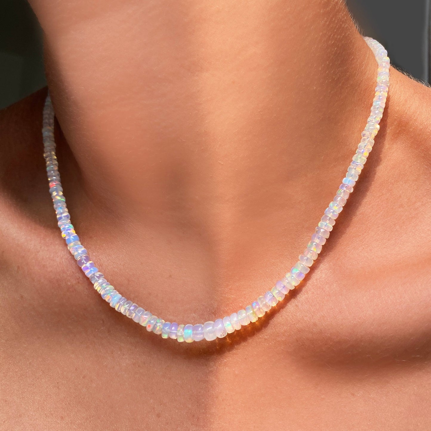 Shimmering beaded necklace made of smooth opal rondels in shades of clear opals on a slim gold lobster clasp.