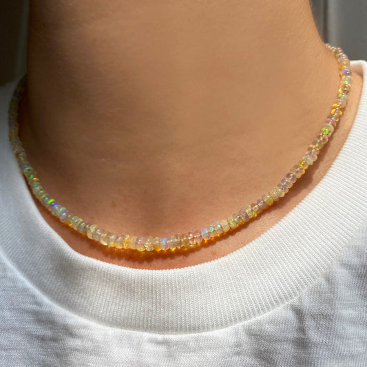 Shimmering beaded necklace made of smooth opal rondels in shades of clear natural opals on a slim gold lobster clasp.