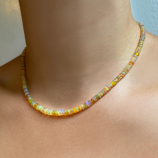 Shimmering beaded necklace made of faceted opals in shades of yellow, orange, and clear opals on a gold linking ovals clasp.