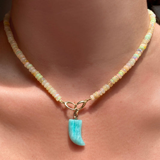 Amazonite horn charm. Styled on a neck hanging from oval clasps of a beaded necklace.