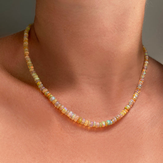 Shimmering beaded necklace made of smooth opal rondels in shades of light yellow and clear opals on a slim gold lobster clasp.