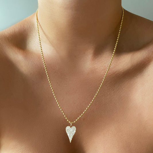 14k yellow gold medium diamond pave heart charm styled on a neck with the beaded chain necklace.