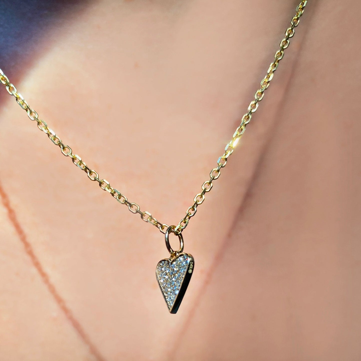 14k gold Diamond Cut Cable Chain Necklace. Styled on a neck with a medium pave heart charm