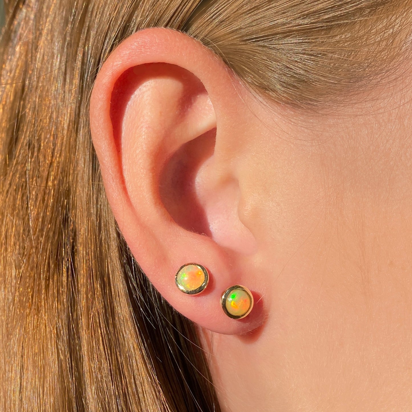 14k gold Ethiopian Opal Stud Earrings styled on a ear