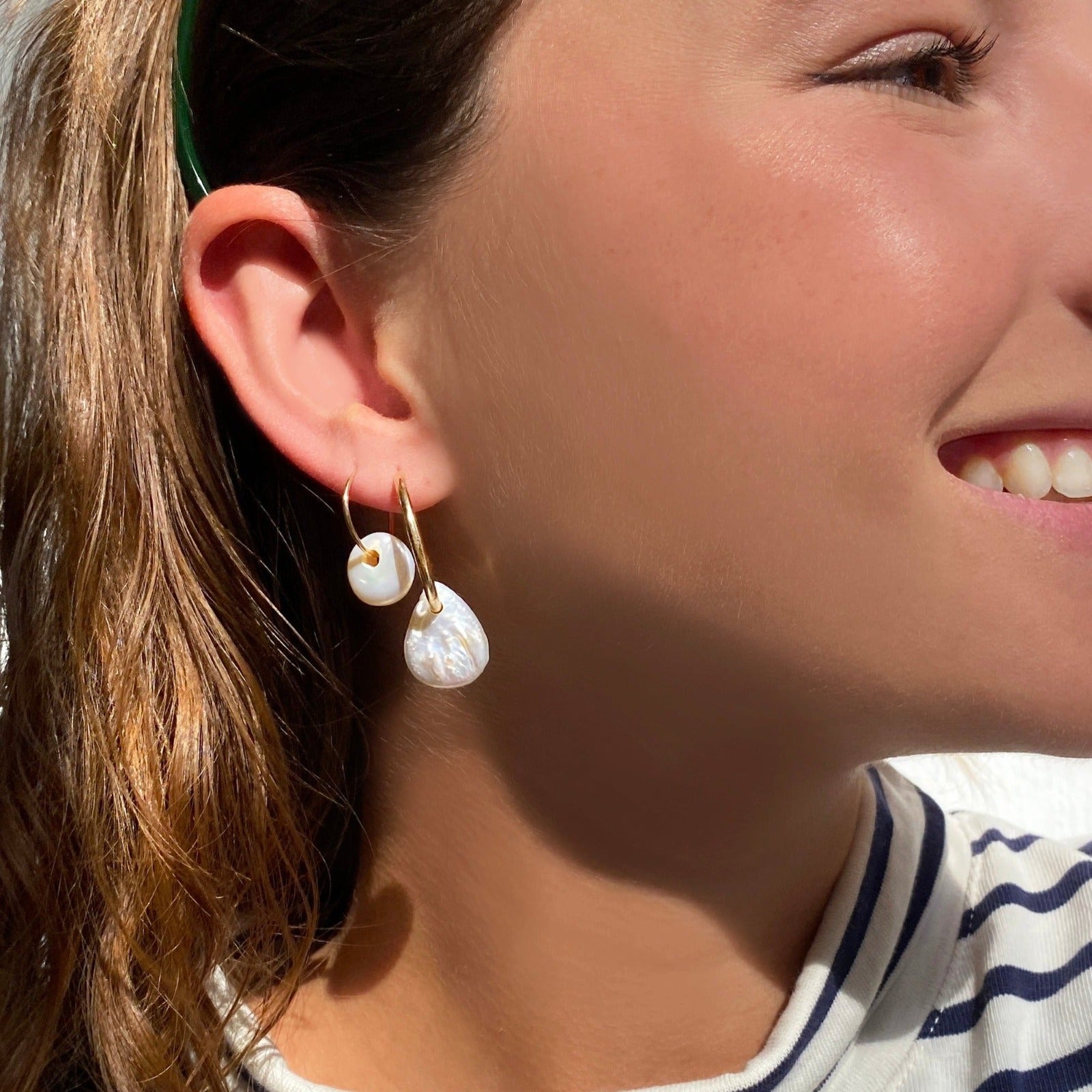 14k gold White Teardrop Coin Pearl Hoops styled on a ear
