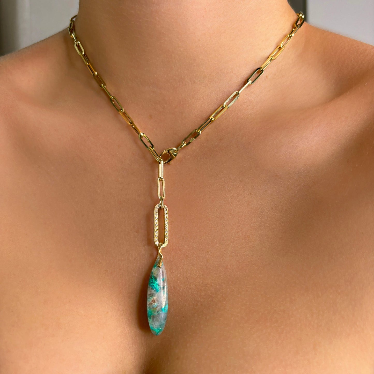 Chrysocolla in Quartz Surfboard Charm. Styled on a neck hanging from a pave oval charm lock on a paperclip chain necklace.