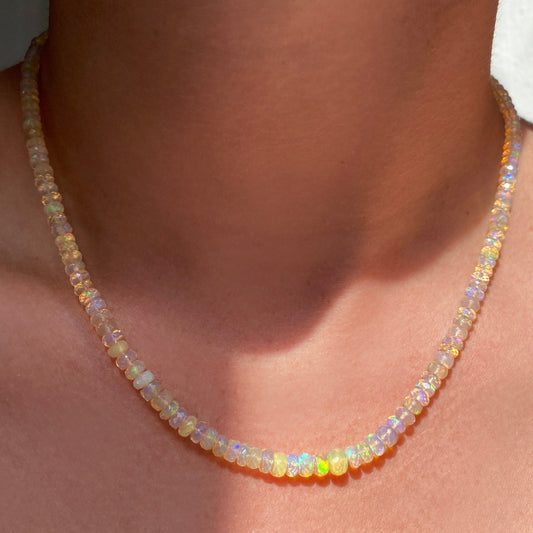 Shimmering beaded necklace made of faceted opals in shades of clear on a gold linking ovals clasp. 