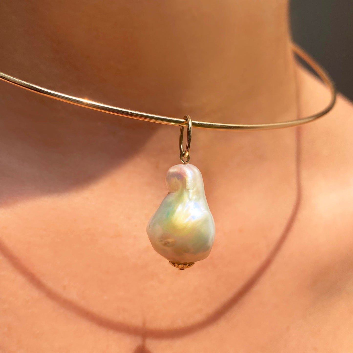 Baroque Pearl Charm. Styled on a neck hanging from a wire choker necklace