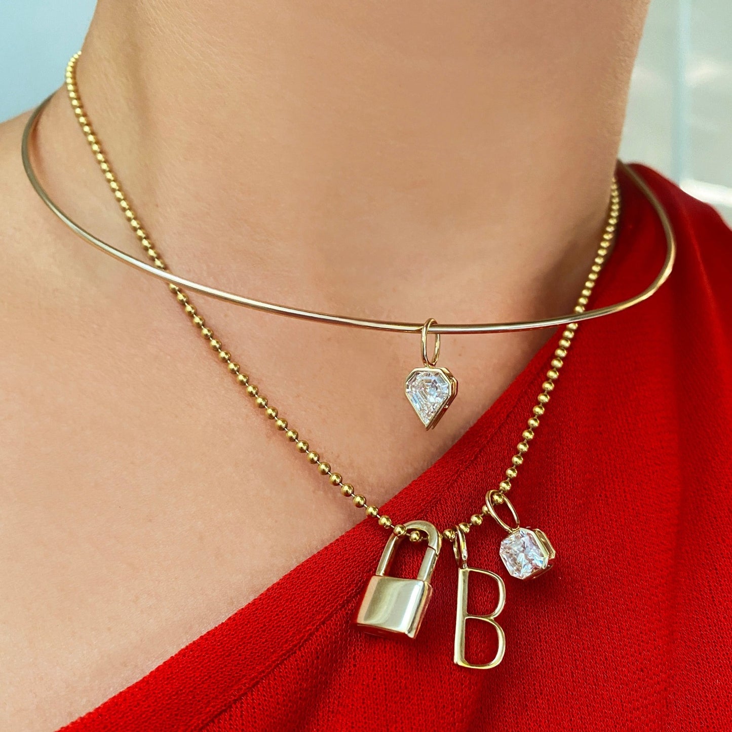 14k gold Shield Diamond Solitaire Charm. Styled on a neck hanging from a wire choker necklace. 