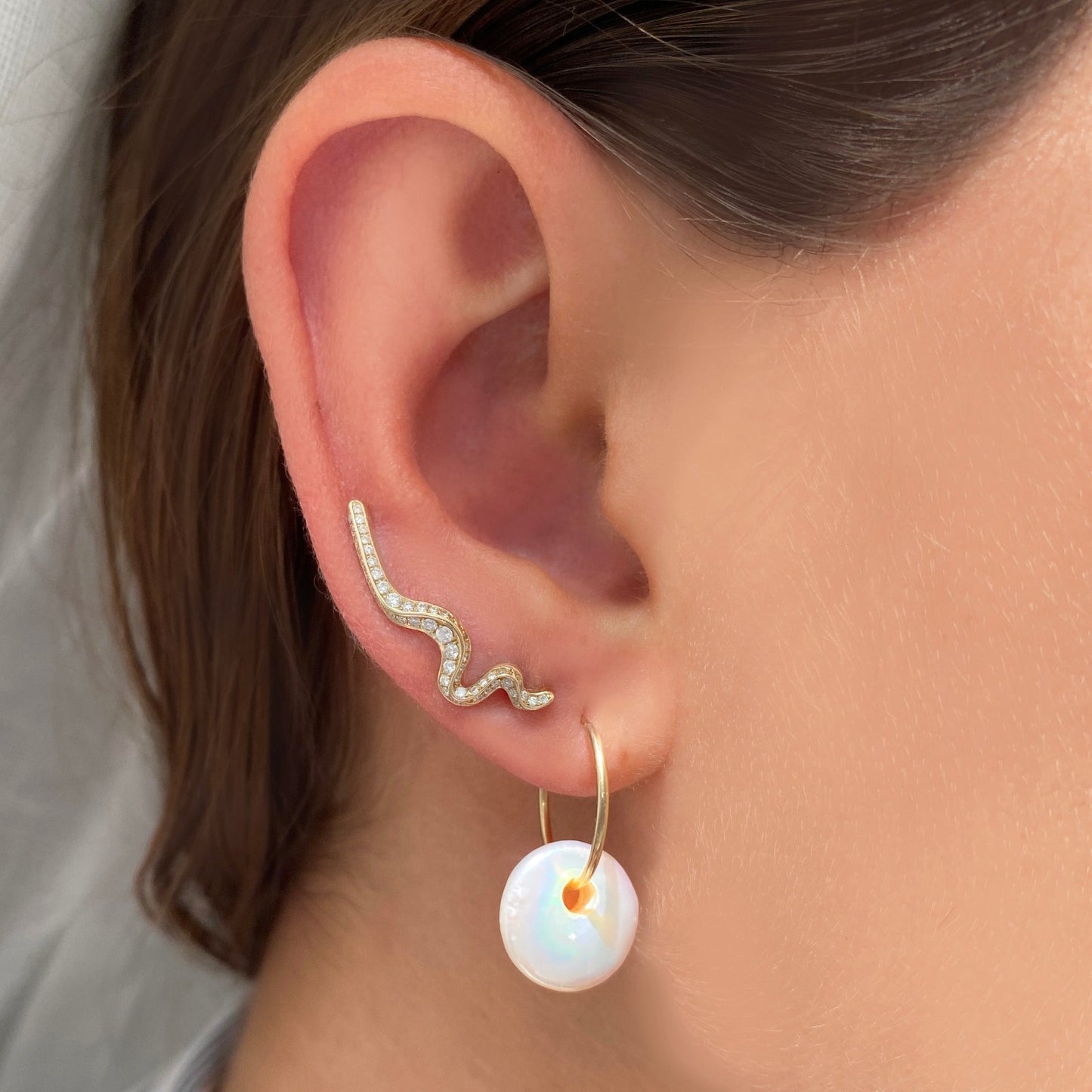 14k gold Full Pave Large Ripple Climber Earrings styled on a ear with a coin pearl hoop