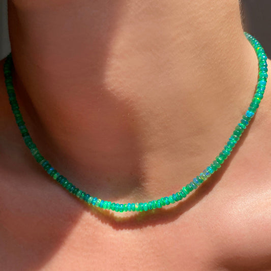 Shimmering beaded necklace made of faceted opals in shades of green on a gold linking ovals clasp.
