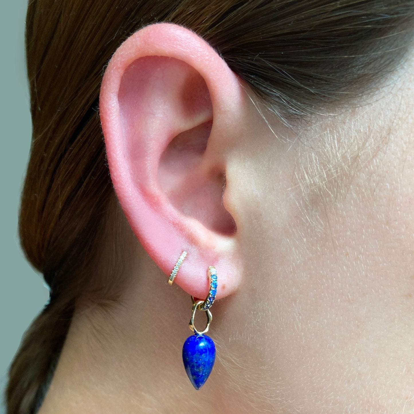 Lapis acorn drop charm. Styled on the ear hanging from a pave hoop.