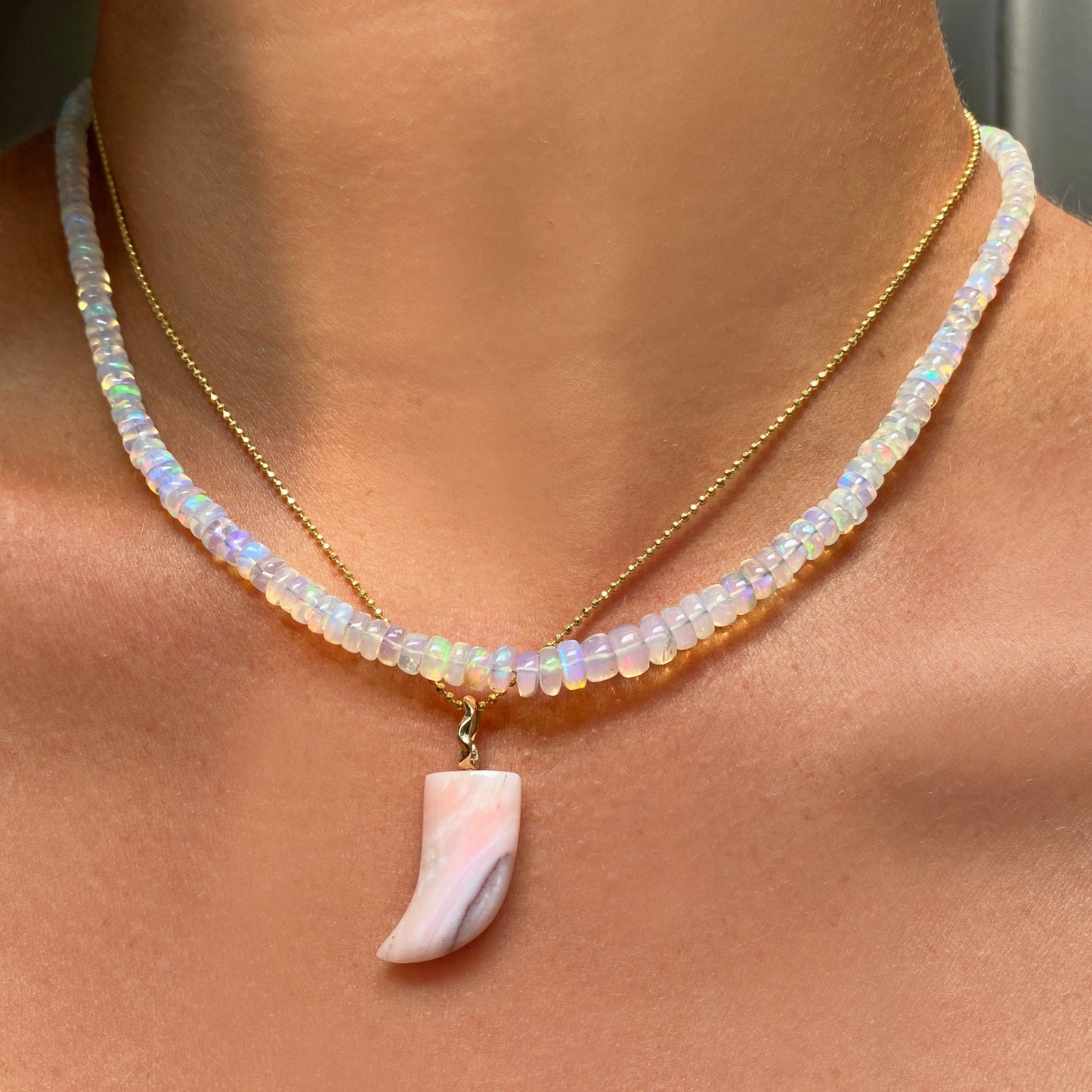 Pink opal horn charm. Styled on a neck hanging from a diamond cut bead chain  necklace.