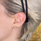 14k gold Stitch Stud Earrings styled on a ear