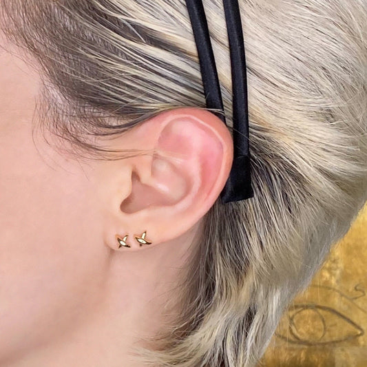 14k gold Stitch Stud Earrings styled on a ear