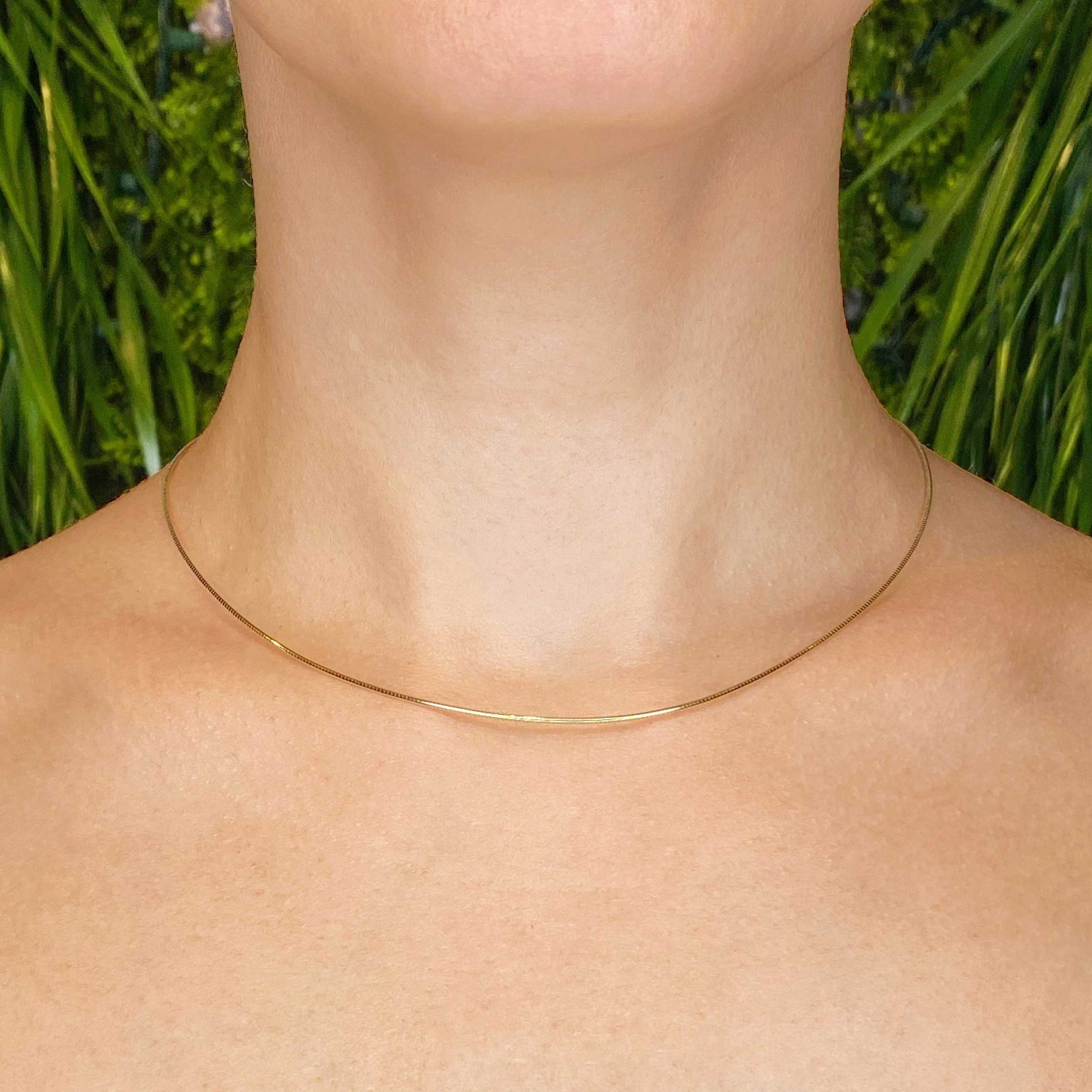 14k gold Omega Choker Necklace styled on a neck