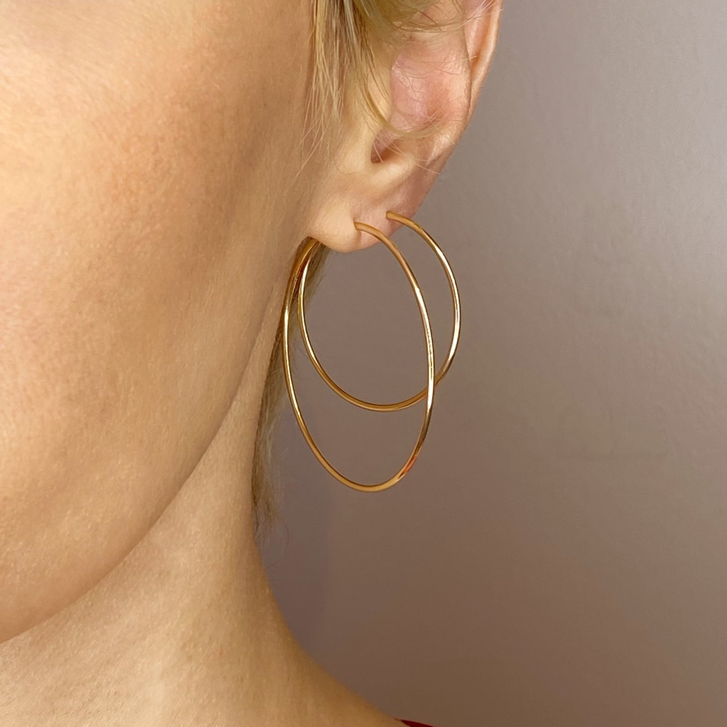 14k gold Endless Hoop Earrings styled on a ear