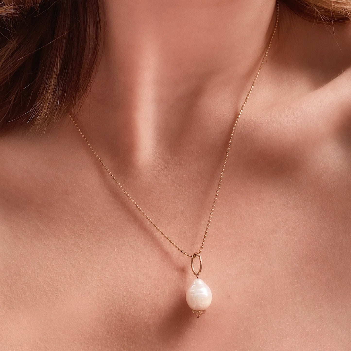 14k gold Diamond Cut Bead Chain Necklace. Styled on a neck with a mini baroque pearl charm