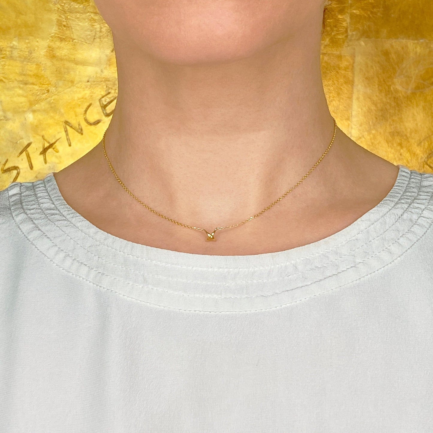 14k gold Stitch Necklace styled on a neck
