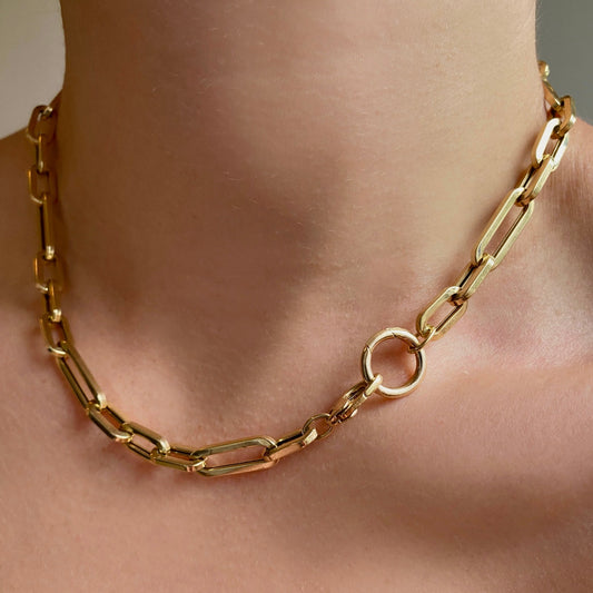 14k gold 13mm Plain Round Charm Lock. Styled on a neck hanging from oval clasps of a chunky paperclip chain necklace. 