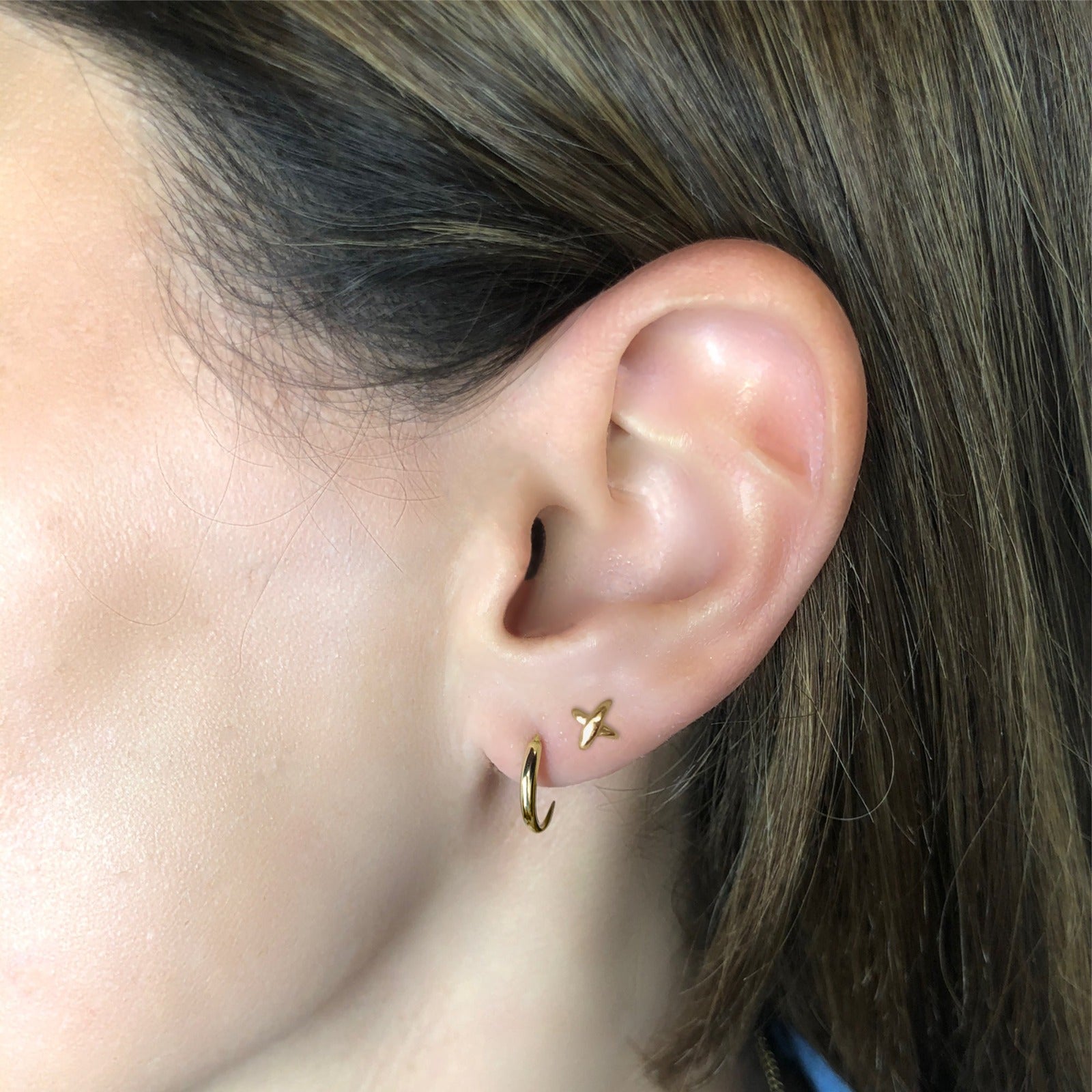 14k gold Stitch Stud Earrings styled on a ear with a quill thorn earring