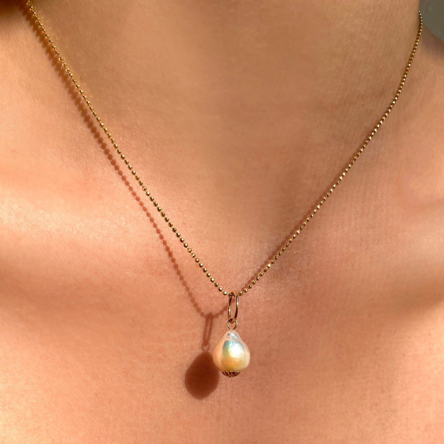 Mini Baroque Pearl Charm. Styled on a neck hanging from a diamond cut bead chain necklace.