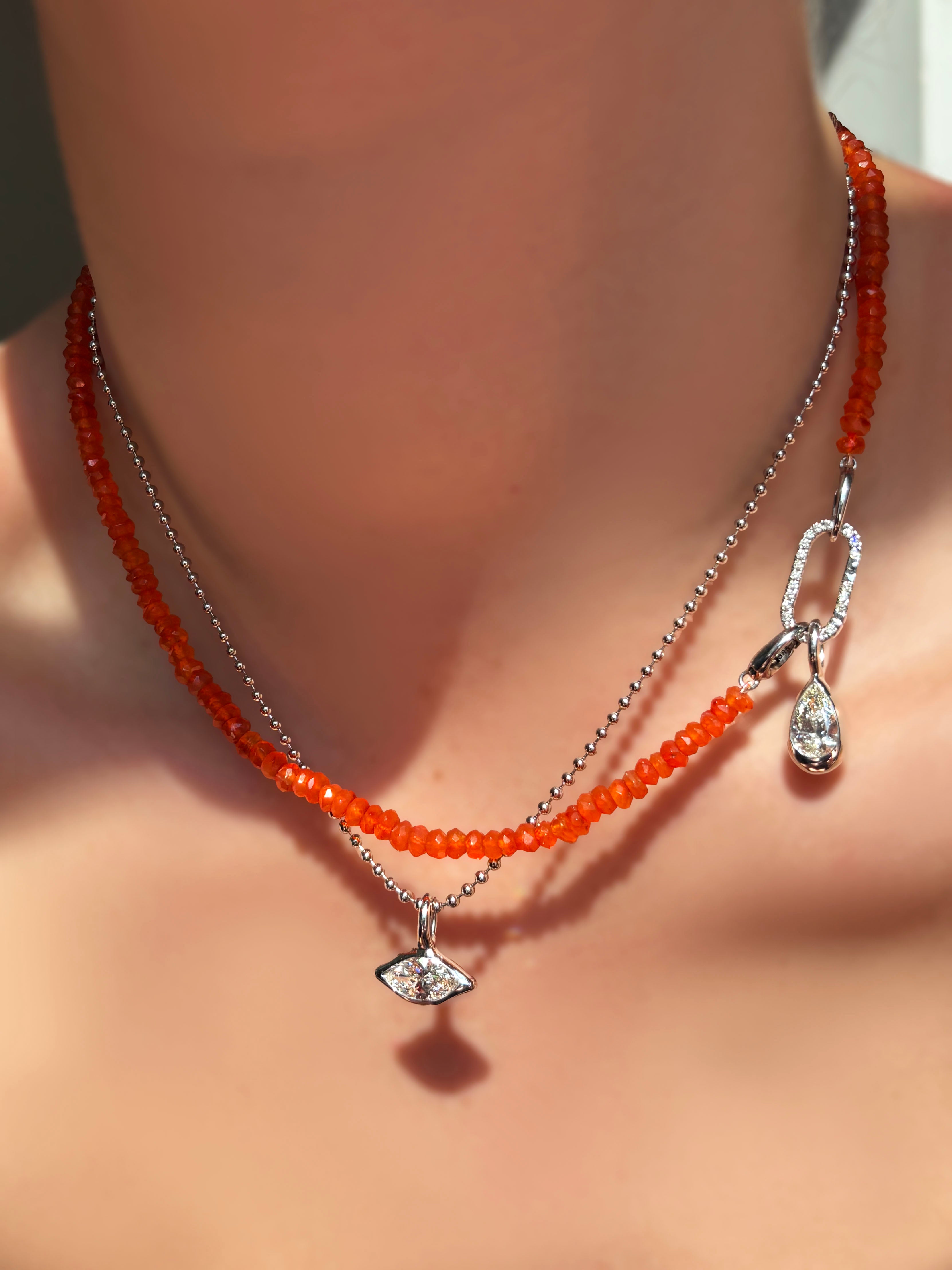 Faceted Carnelian Necklace with medium pave face diamond charm lock dropping pear shaped molten solitaire charm over a bead chain with marquise molten solitaire charm on a model's neck.