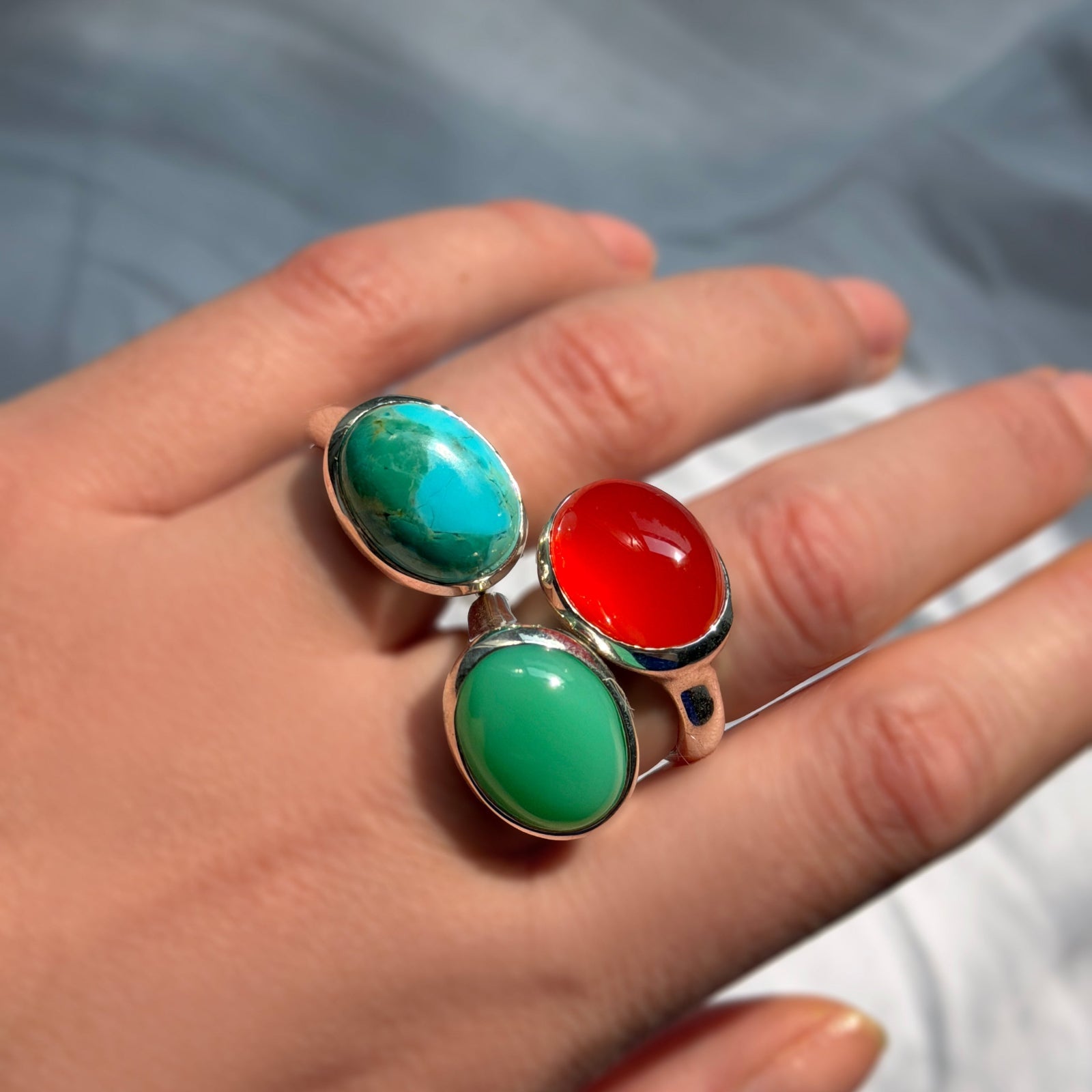 AMANDA PEARL recycled sterling silver and gemstone (turquoise, chrysoprase, and carnelian) rings on a model's hand. 