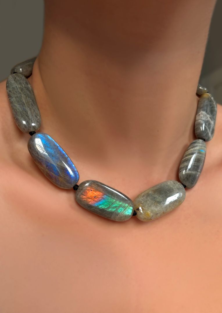 chunky oval labradorite beads on a model's neck.