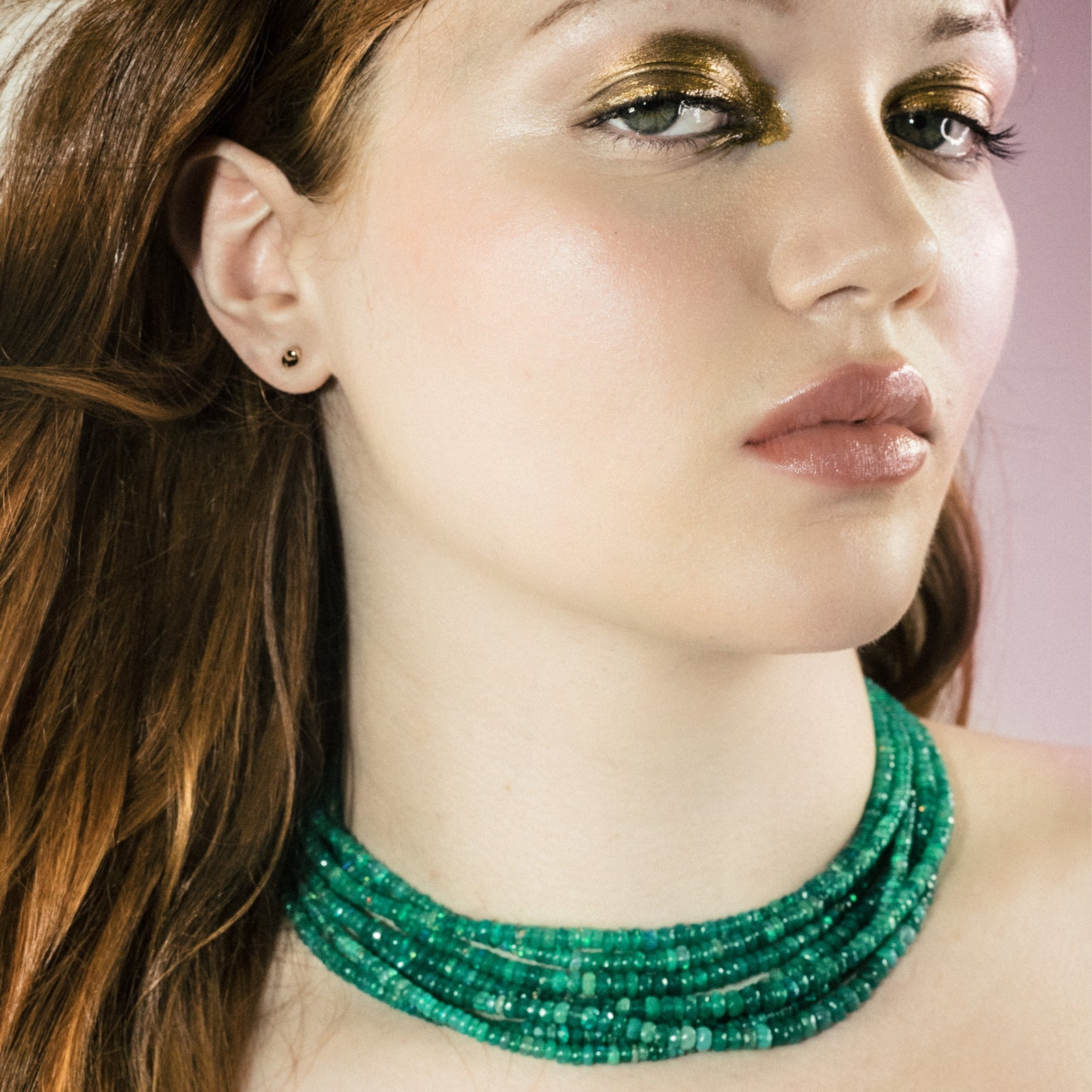 Opals: Shimmering beaded necklace made of faceted opals in shades of light blue, light purple, yellow, white, and clear on a gold linking ovals clasp.