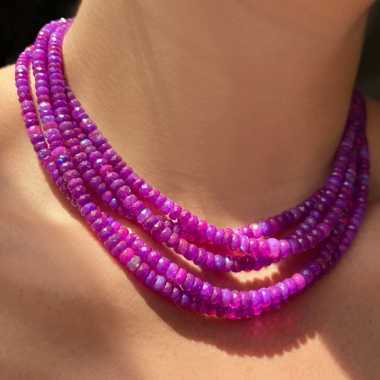 Shimmering beaded necklace made of faceted opals in shades of fuchsia pink on a gold linking ovals clasp. 