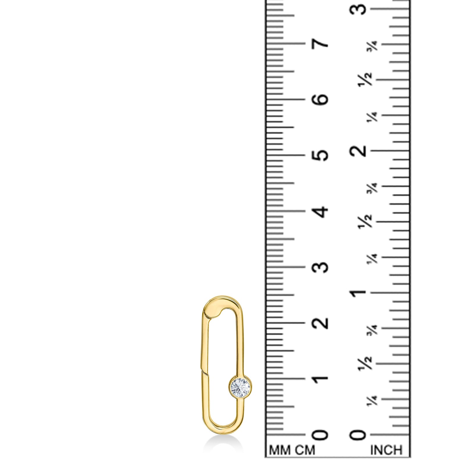 A 14K YG paperclip charm is displayed on a white background with a ruler next to it for scale. It demonstrates that the charm lock is 25mm in height. The charm lock features a small white diamond which sparkles.