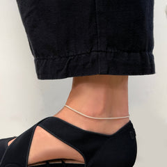 Recycled Sterling Silver Round foxtail chain on a model's ankle with black barrel leg pants and black neoprene dior sandals.