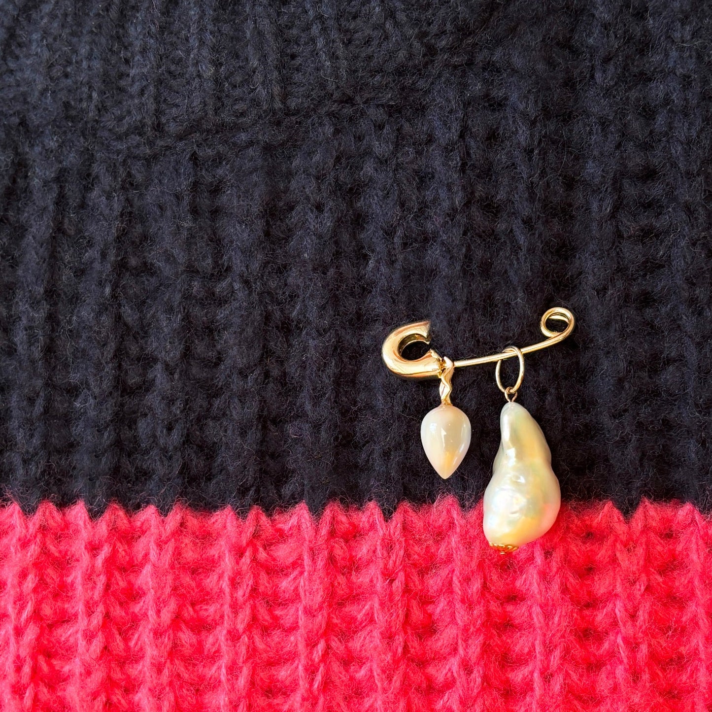 14k yellow gold safety pin charm lock. Styled on a sweater with an acorn drop charm and baroque pearl charm.