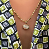 3mm bead chain with small oval molten solitaire charm on a model's neck.