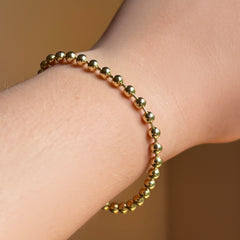 4mm bead chain in yellow gold on the wrist.