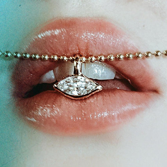 14K Recycled Gold Molten Solitaire Charm in Marquise, layered on gold bead chain between lips