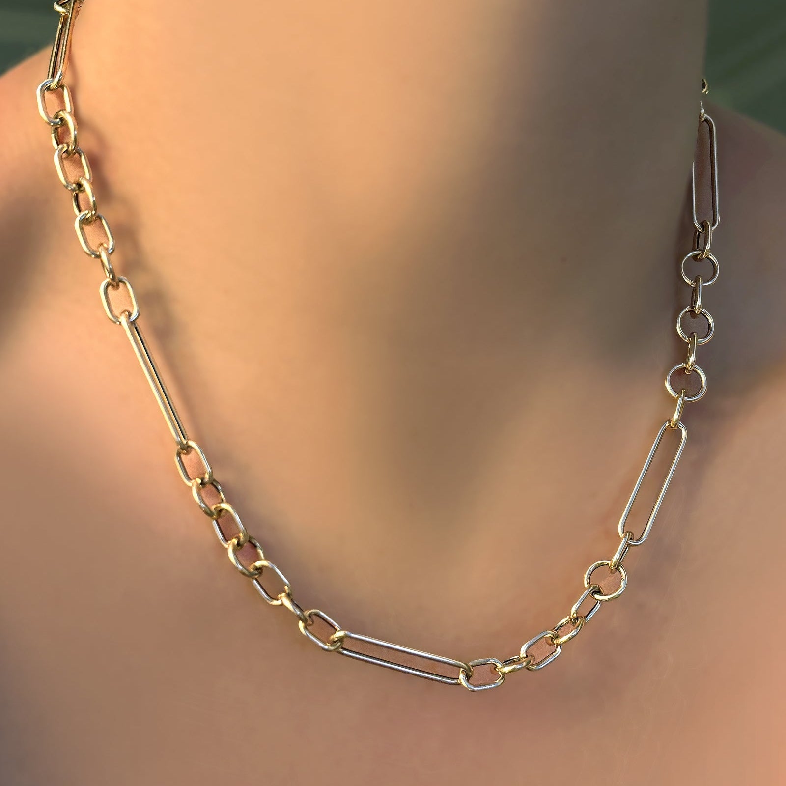 Chunky irregular cable chain necklace on a model's neck.