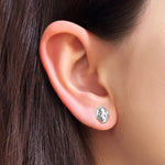 AMANDA PEARL sterling silver molten skull stud earring on a model's ear.