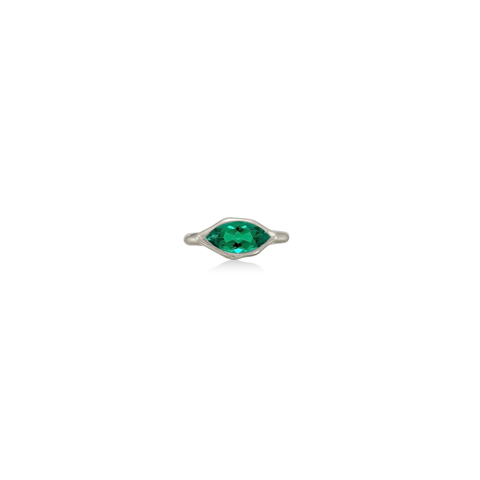 A 14K white gold marquise ring, with a bezel set faceted emerald gemstone, sits on a white background with drop shadow.