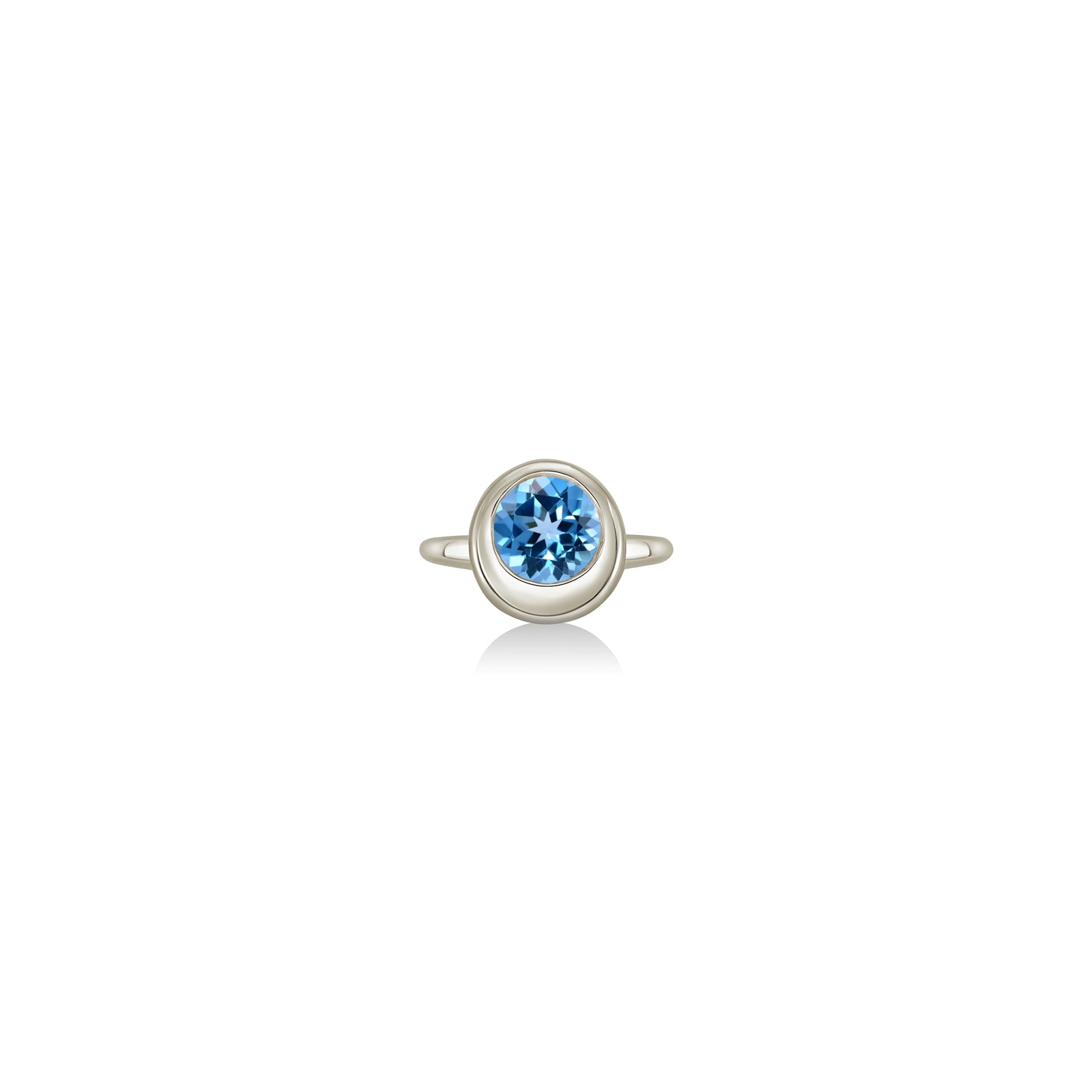 A 14K white gold round ring, with a bezel set faceted blue topaz gemstone, sits on a white background with drop shadow.