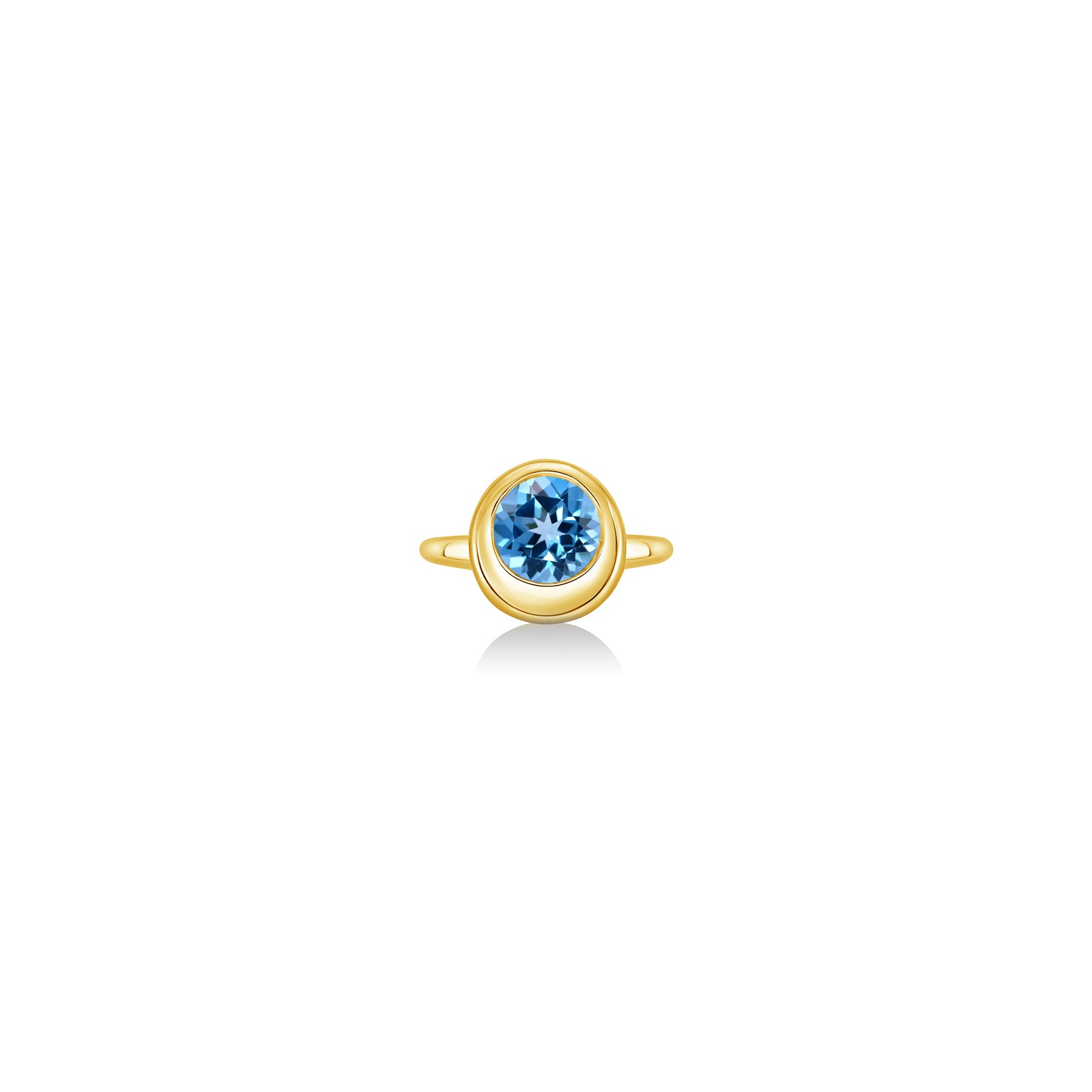 A 14K yellow gold round ring, with a bezel set faceted blue topaz gemstone, sits on a white background with drop shadow.